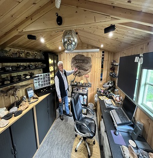 A man showcases his fossil and geology collection in a shed